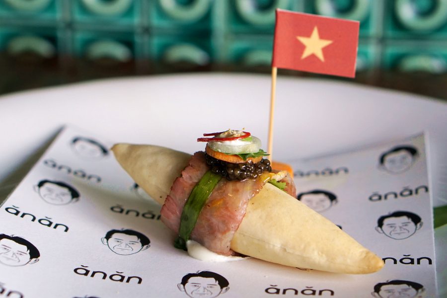 Close-up view of a small banh mi at Anan Saigon adorned with a min Vietnamese flag.  